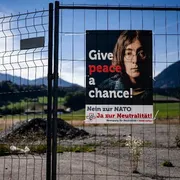 Una rete metallica, manifesto con foto di Lennon