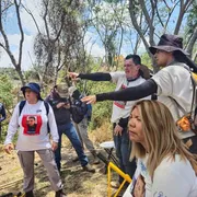 Familiari cercano in uno sterrato alla periferia di Guadalajara. Indossano magliette bianche con le foto dei parenti scomparsi