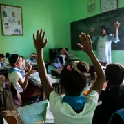 Bambini alzano le mani in classe