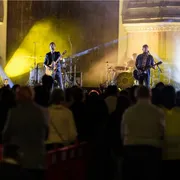 Una band musicale composta da quattro persone suona su un palco davanti al pubblico