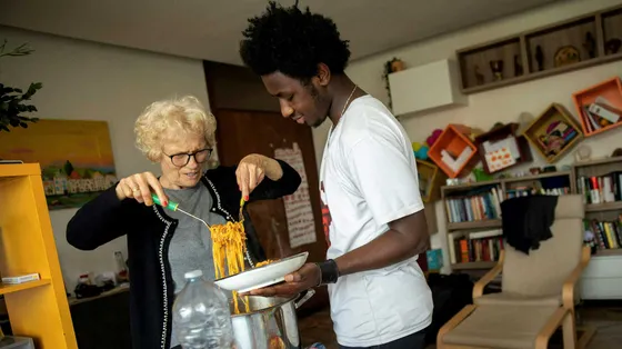 Mamajang dal Gambia con la nonna Maria, a Montecchio Maggiore (Vicenza), mentre servono in tavola la pastasciutta preparata insieme / UNICEF