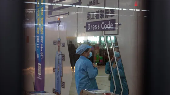 Una dipendente al lavoro presso lo stabilimento Jabil che produce PCB (circuiti stampati) e altri componenti elettronici, a Wuxi, in Cina
