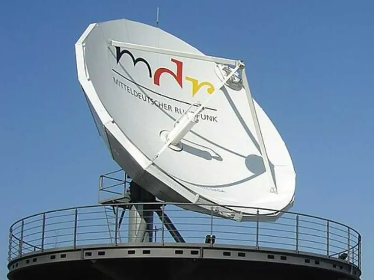 Una grande parabola televisiva bianca puntata verso il cielo