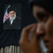 Una donna piange davanti alla foto dell'ayatollah Khamenei