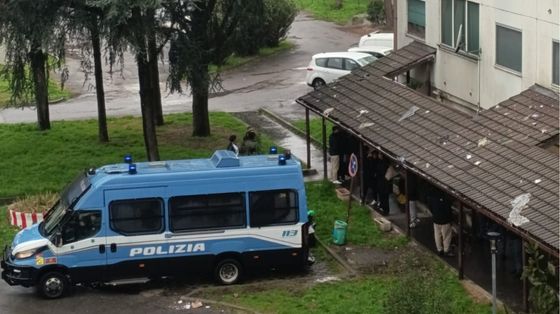 Una camionetta della polizia all'esterno del palazzo di via Quarti, 31 a Milano, dove è stata eseguita l'ordinanza di sgombero
