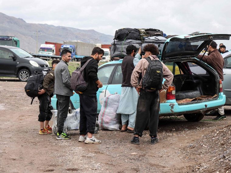 Migranti afghani radunati accanto a un veicolo pronti a tornare nelle proprie case vicino al confine tra Afghanistan e Iran, nel distretto di Zendeh Jan a Herat