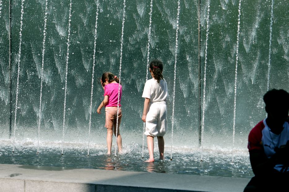 Due bambine si rinfrescano in una fontana di Milano