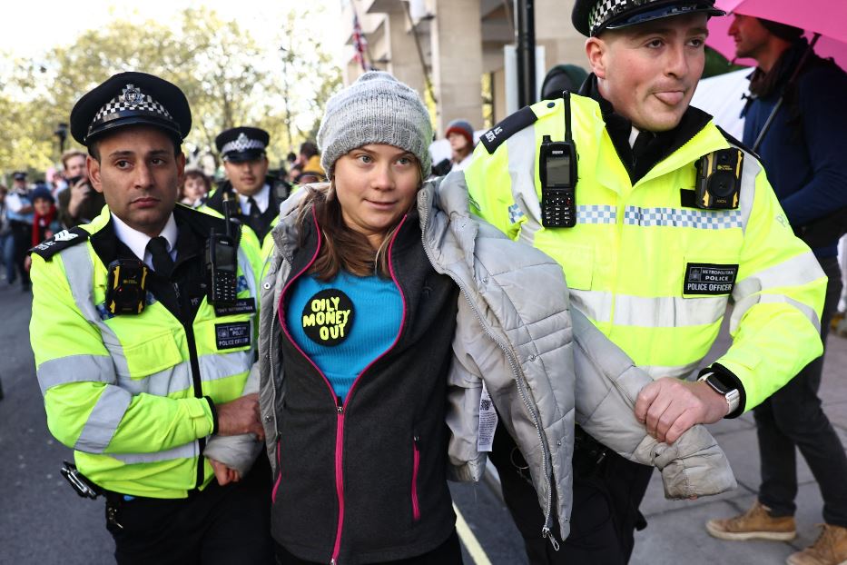 Gli agenti fermano Greta Thunberg. La scritta sulla sua maglietta recita: 'Via i soldi sporchi di petrolio'