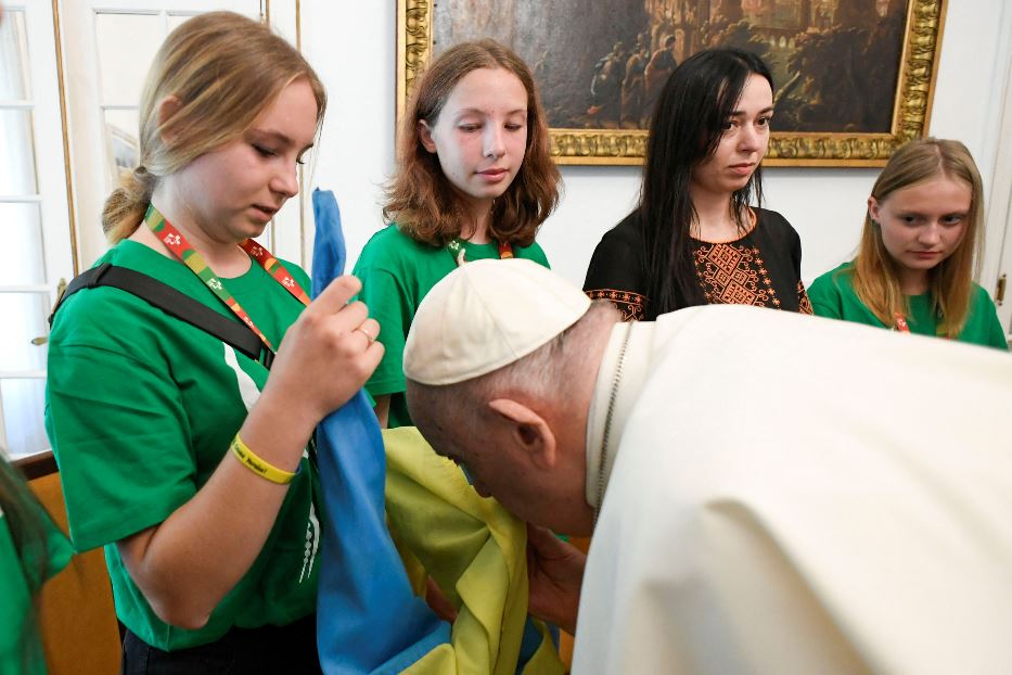 Papa Francesco bacia la bandiera ucraina incontrando un gruppo di giovani dal Paese in guerra