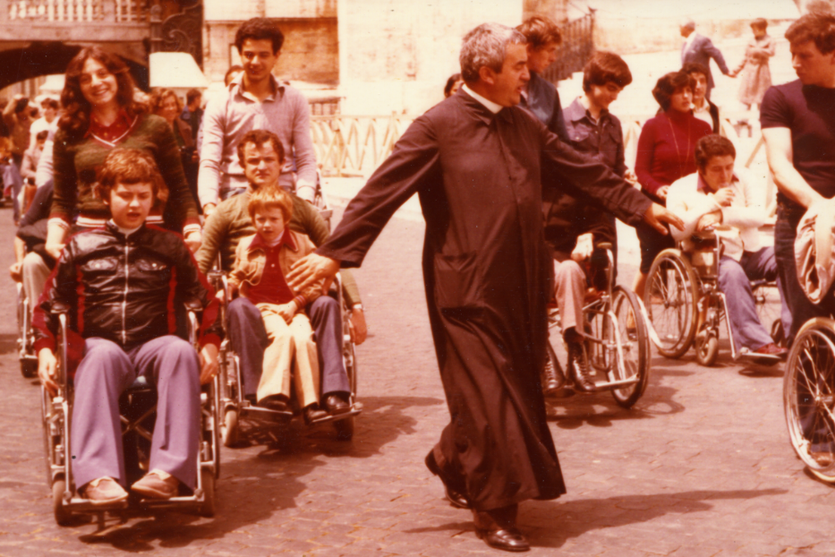 Un giovane don Benzi con i suoi disabili in piazza San Pietro