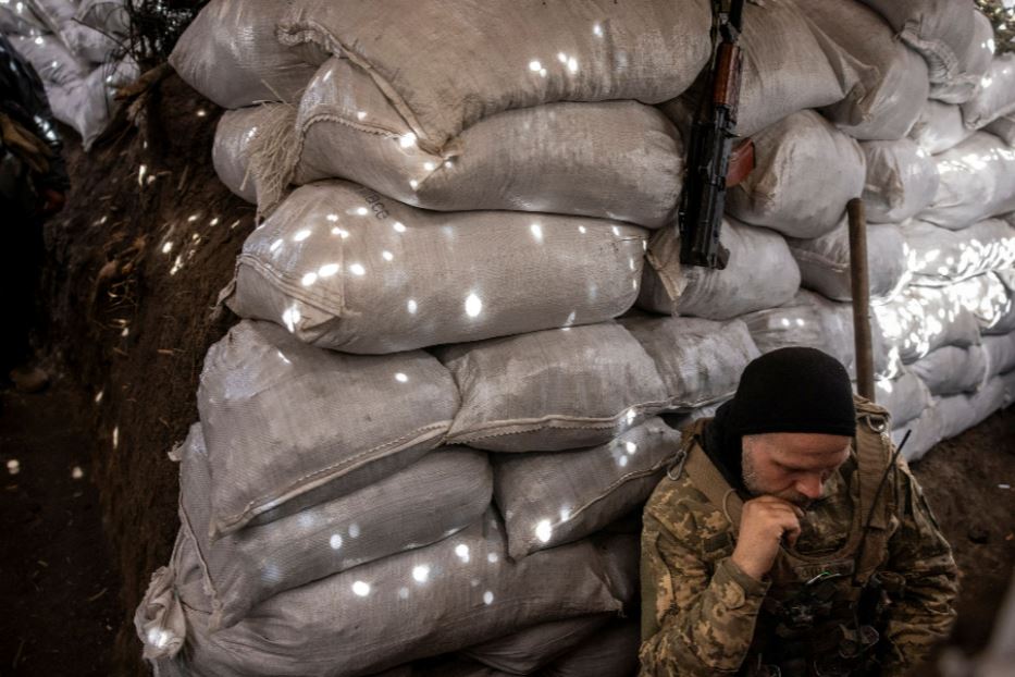 Un soldato ucraino ascolta la radio in una trincea nel Donetsk