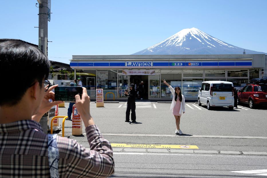 Lo scatto social di turisti da social davanti al supermercato Lawson a Fujikawaguchiko