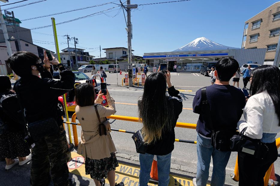 Turisti da social davanti al supermercato Lawson a Fujikawaguchiko