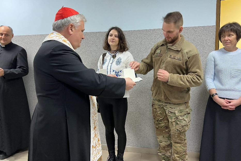 Il cardinale Konrad Krajewski con un giovane miliare cattolico a Kharkiv