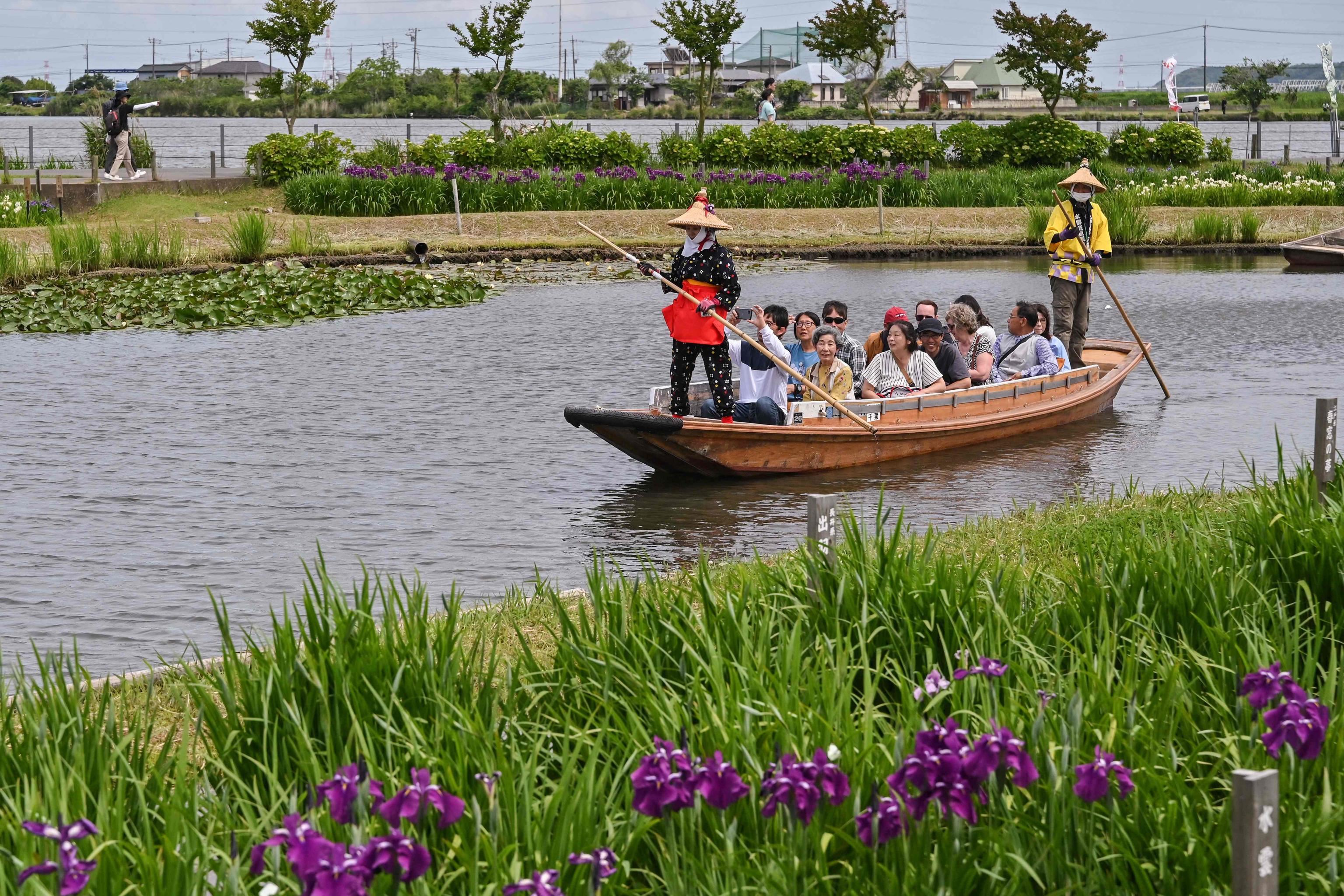 Turisti fanno una gita in barca al Suigo Sawara Ayame Park, nella città di Katori