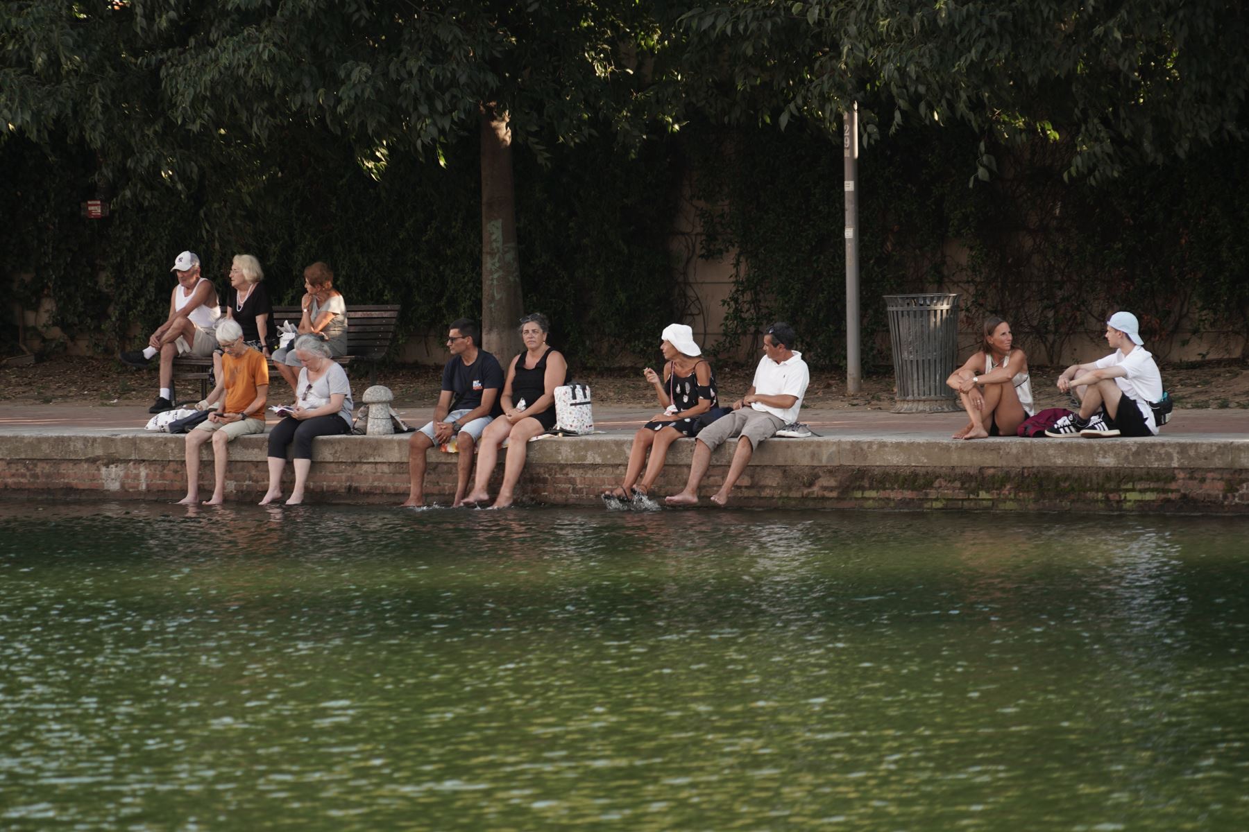 Turisti cercano di trovare un po' di fresco in Darsena, a Milano