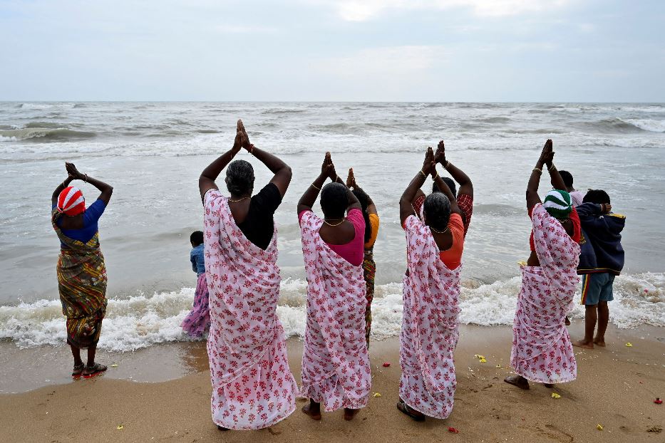 Un gruppo di donne in preghiera sulla spiaggia di Chennai, in India