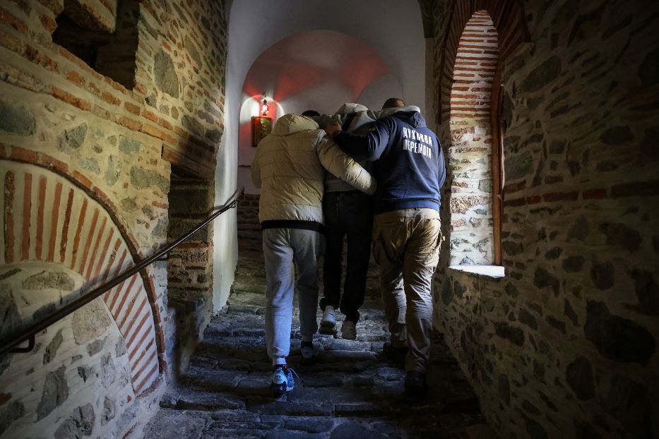 I commilitoni portano a braccio Ivan, 22 anni, amputato di entrambe le gambe, lungo l'acciottolato che sale ai monasteri del monte Athos