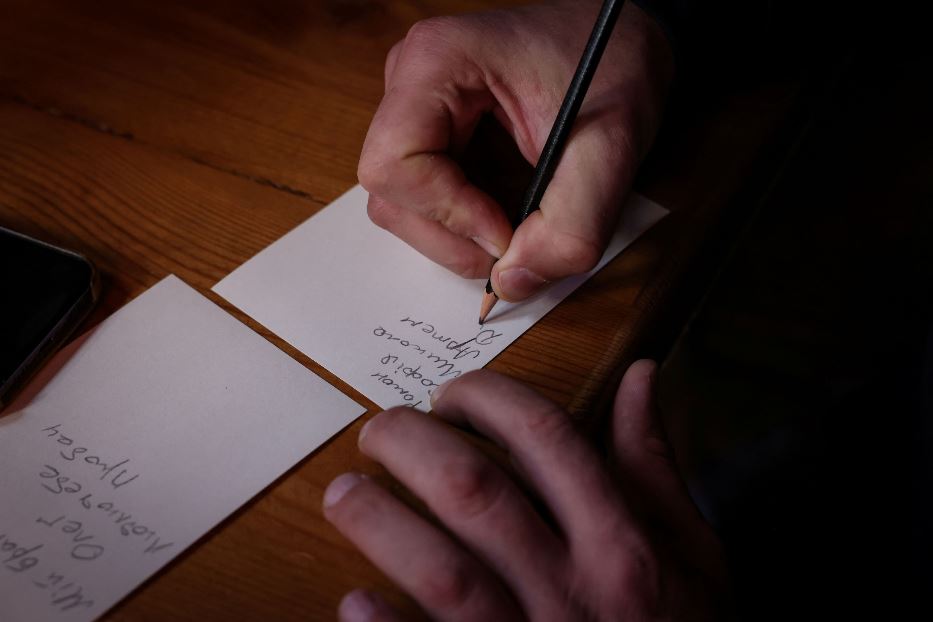 Un soldato scrive su un foglietto il nome delle persone per le quali pregare