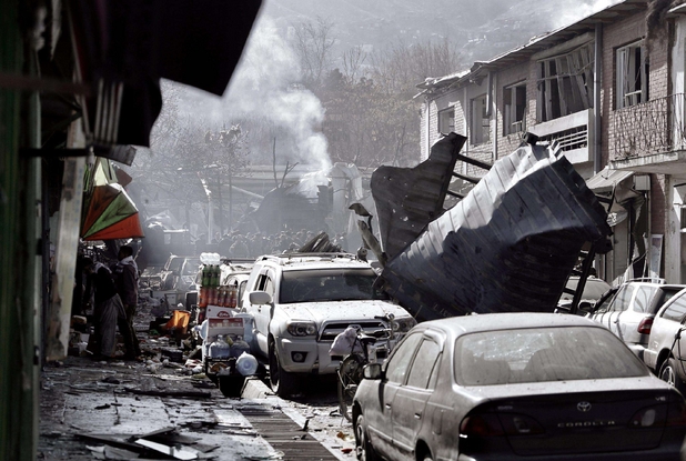 Fumo sale dalle macerie a Kabul dopo l'attentato kamikaze di sabato che ha fatto 95 vittime (Afp)