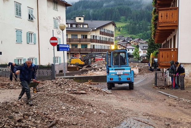 Gli uomini della Protezione civile al lavoro per sgomberare le strade di Moena dal fango