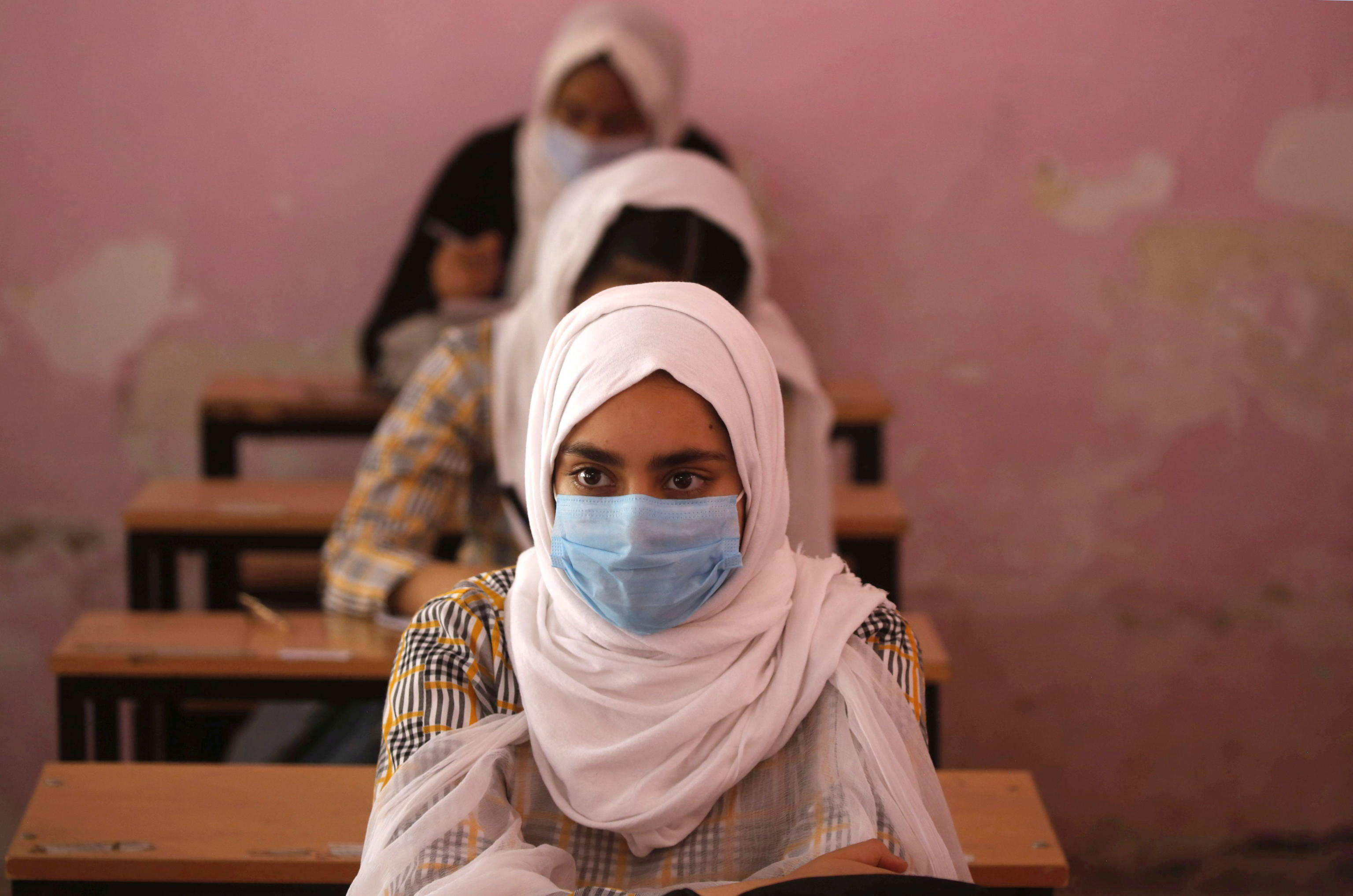 Studentesse in classe a Srinagar, nel Kashmir. Per le regole anti-Covid, solo il 50% della classe può partecipare alle lezioni in presenza - Ansa