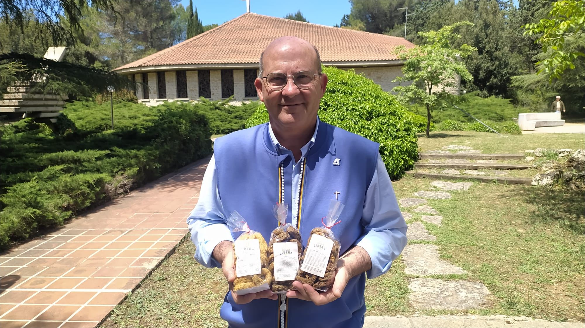 Don Riccardo Agresti mostra i prodotti della coop “A Mano Libera”
