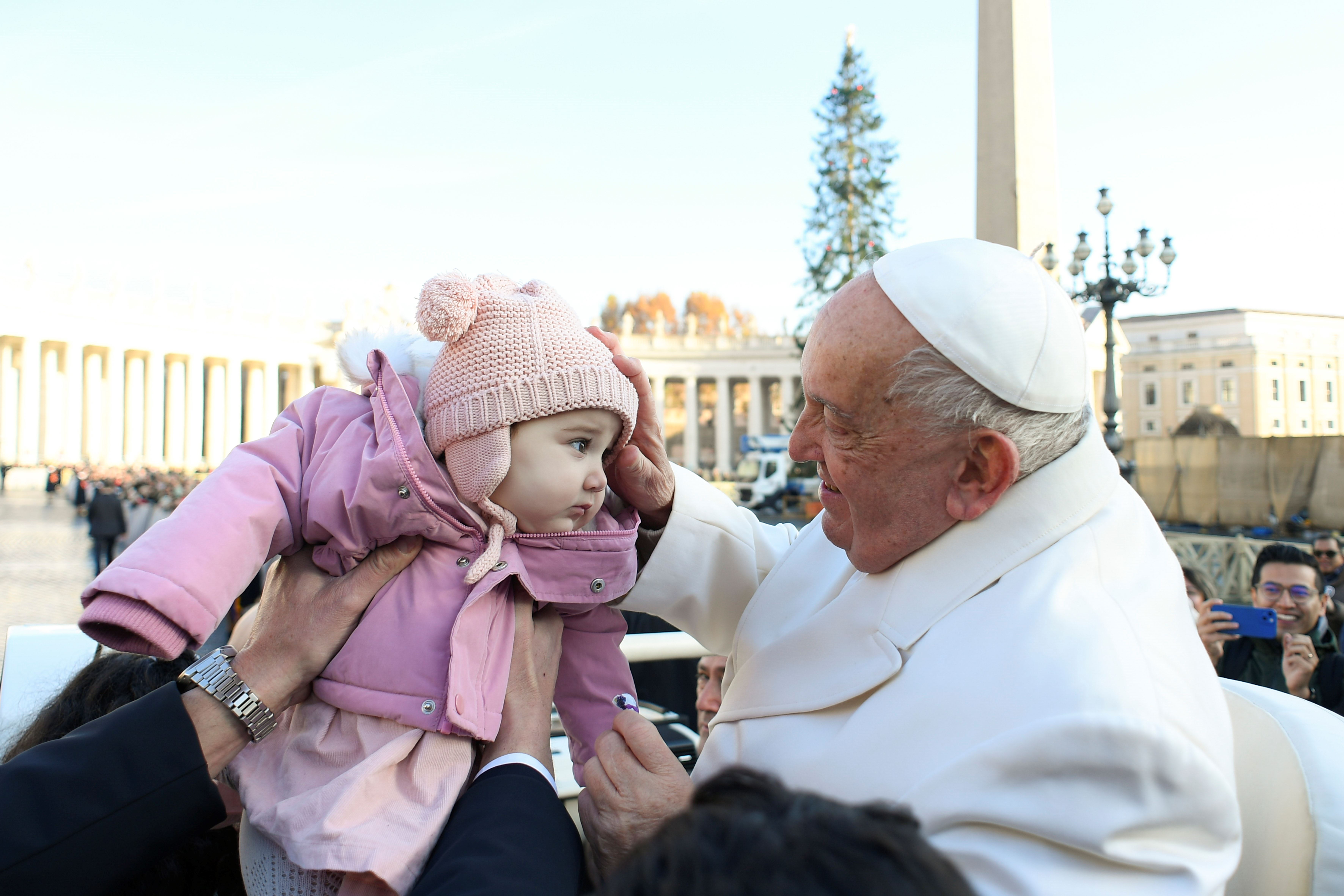 Il Papa benedice un bambino, segno di speranza e di pace