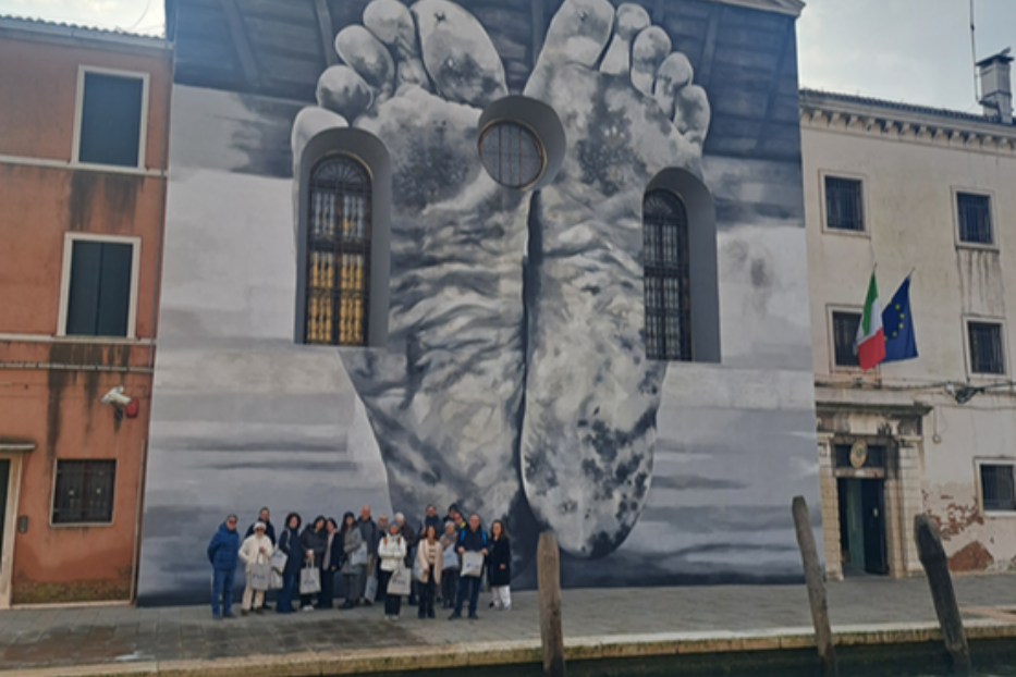 Vivi Avvenire alla Biennale d'arte di Venezia, un gruppo di partecipanti sotto l'opera di Maurizio Cattelan fuori dal carcere femminile della Giudecca che ospita il Padiglione della Santa Sede