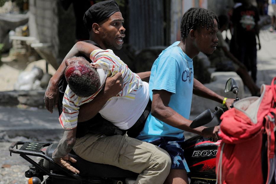 Soccorsi a un bambino ferito negli scontri a Port-au-Prince