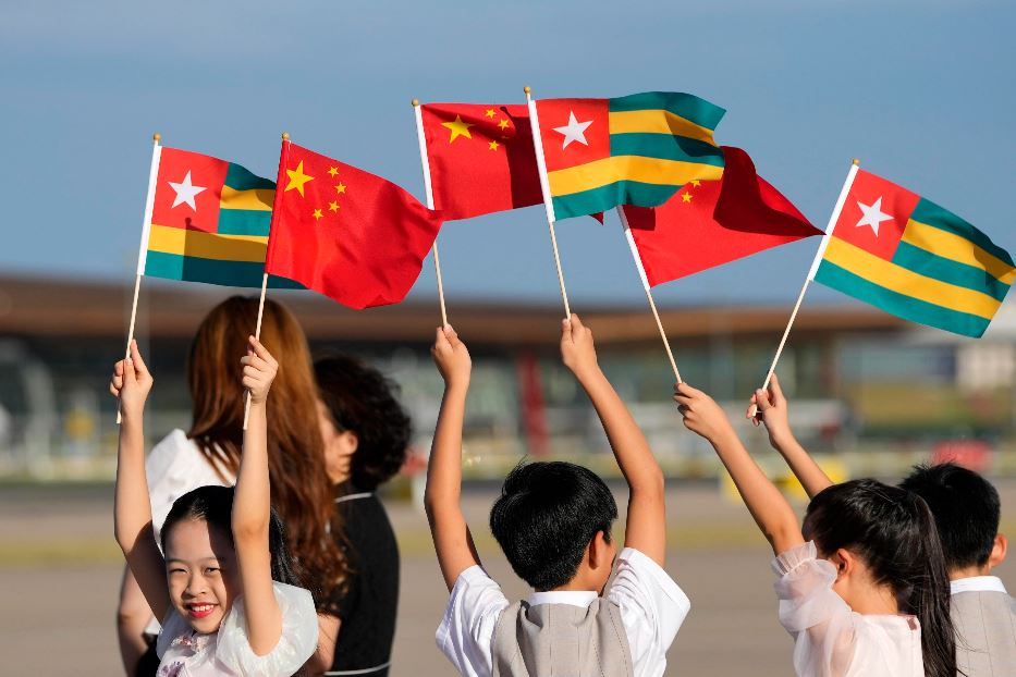 Bambini cinesi sventolano bandierine di Cina e Togo per accogliere a Pechino il presidente togolese Faure Gnassingbe