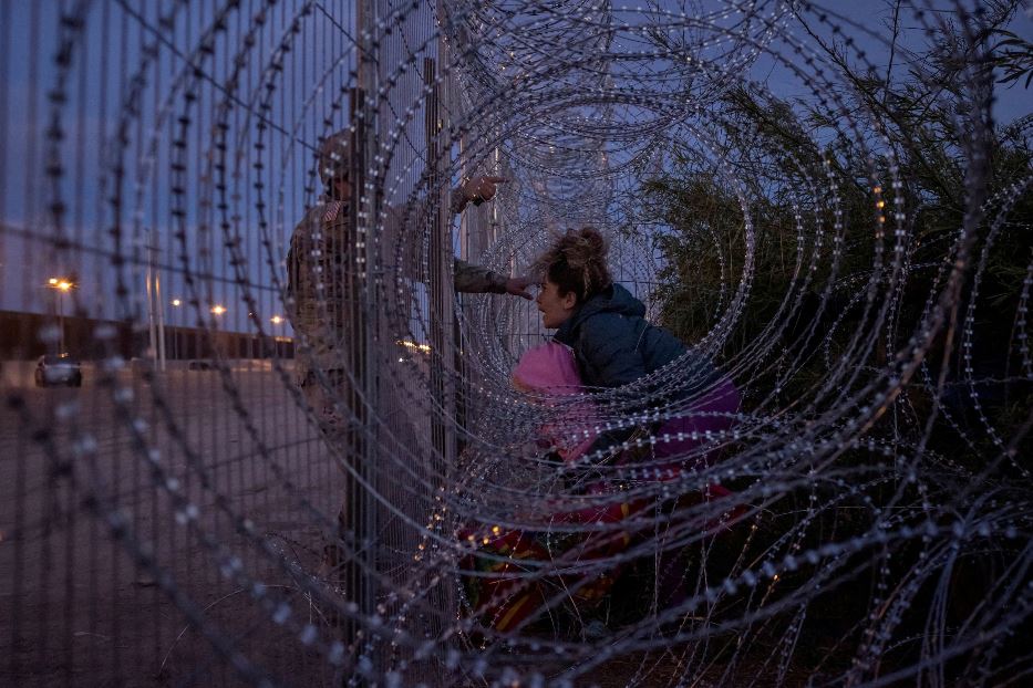 Eliana, 22 anni, migrante venezuelana stringe la figlia Chrismarlees di tre anni mentre urla a un agente della Guardia Nazionale, cercando di superare il filo spinato che corre lungo la sponda del Rio Grande a El Paso, in Texas, sul confine con il Messico: sua figlia Eliana, di 6 anni, aveva oltrepassato la barriera con altri migranti. Foto scattata il 26 marzo 2024