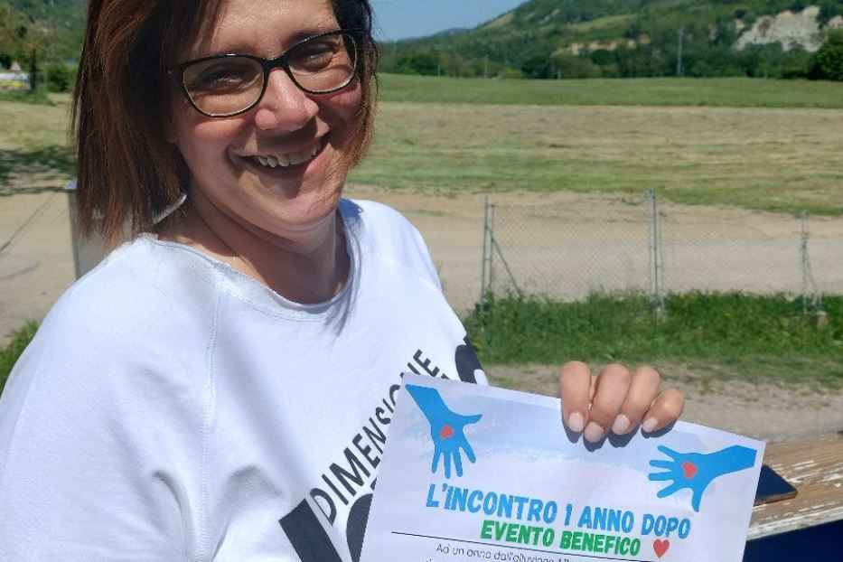Rita Nanni col cartello dell'iniziativa organizzata in pizzeria