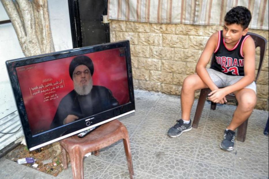 Un ragazzino a Tripoli segue in tv il discorso di Nasrallah