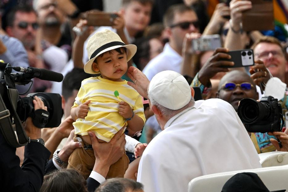 Papa Francesco saluta un piccolo pellegrino durante l'udienza generale in piazza San Pietro di mercoledì 22 maggio 2024