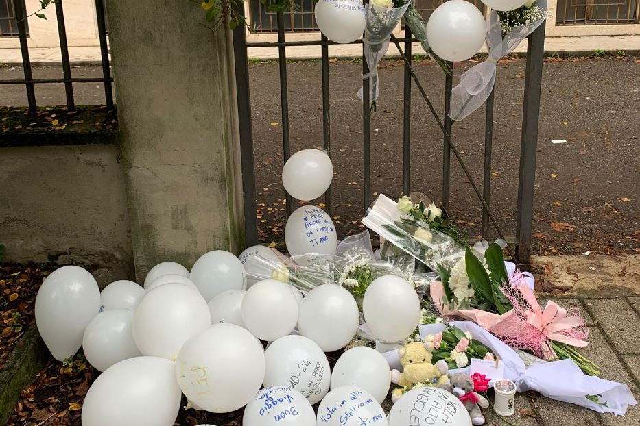 Palloncini bianchi davanti alla scoula di Aurora, morta dopo essere caduta dal terrazzo, forse spinta da un amico