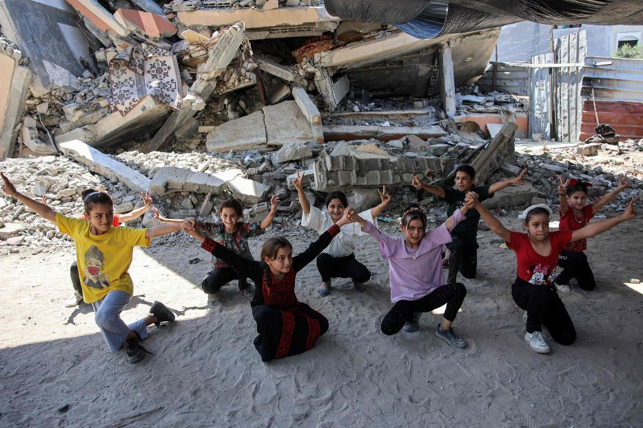 Un gruppo di bambini esegue esercizi di ginnastica tra le rovine in un centro educativo a Jabalia, nel nord della Striscia di Gaza