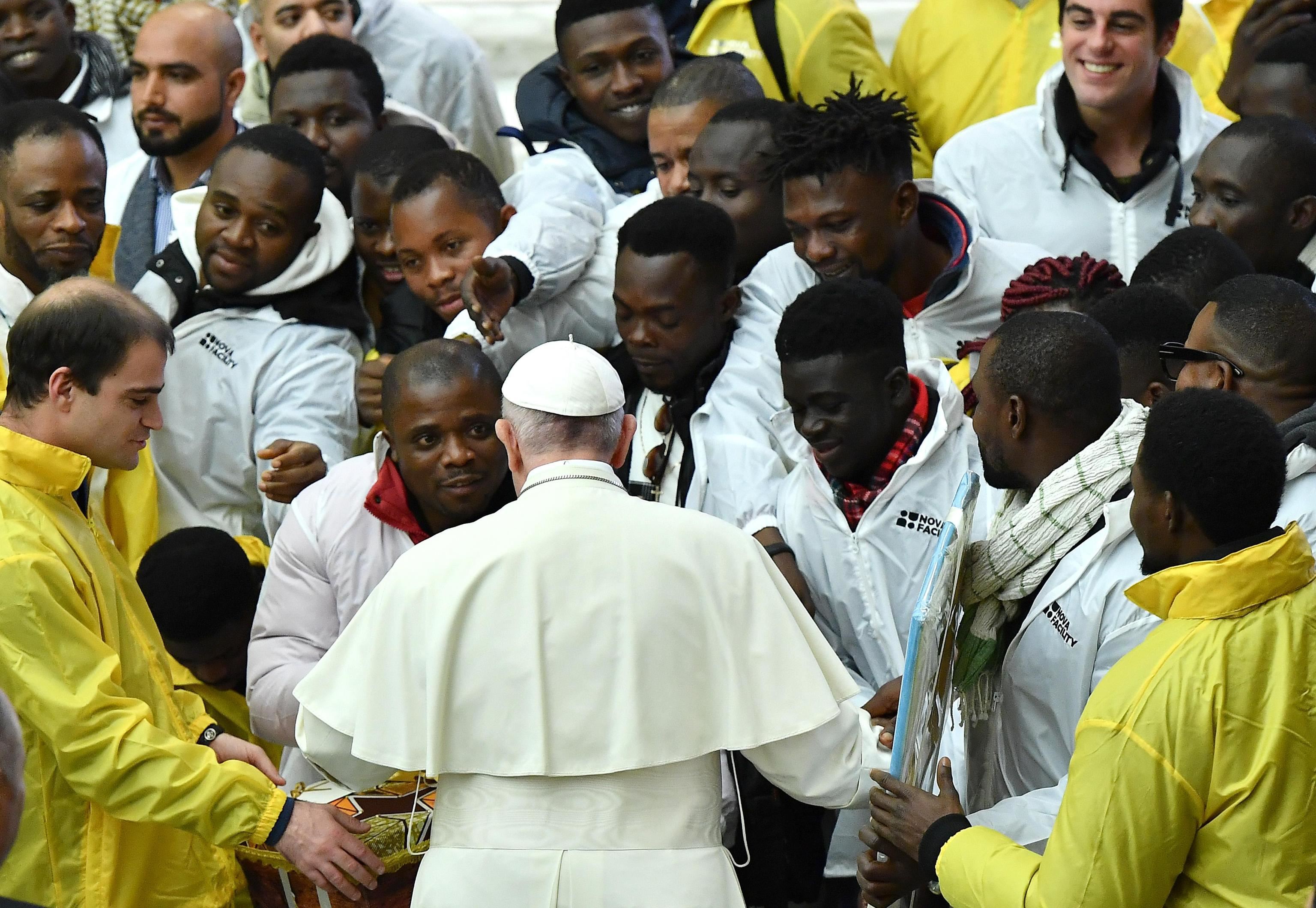 Il Papa con un gruppo di migranti, durante un'udienza generale