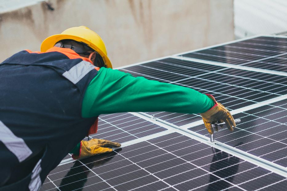 Un installatore di pannelli fotovoltaici all'opera