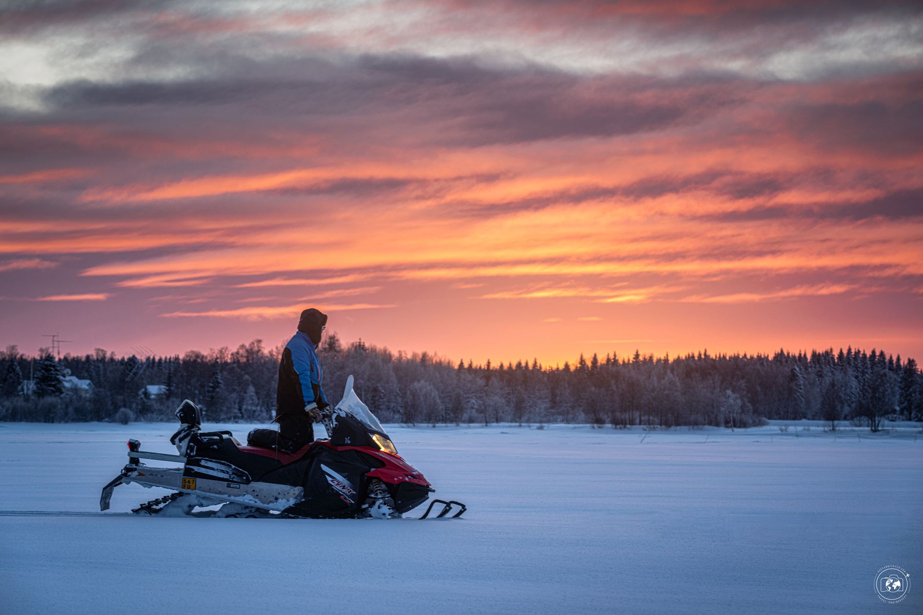 Un lappone osserva il tramonto a bordo della sua motoslitta mentre si reca a pesca - © Stefano Tiozzo