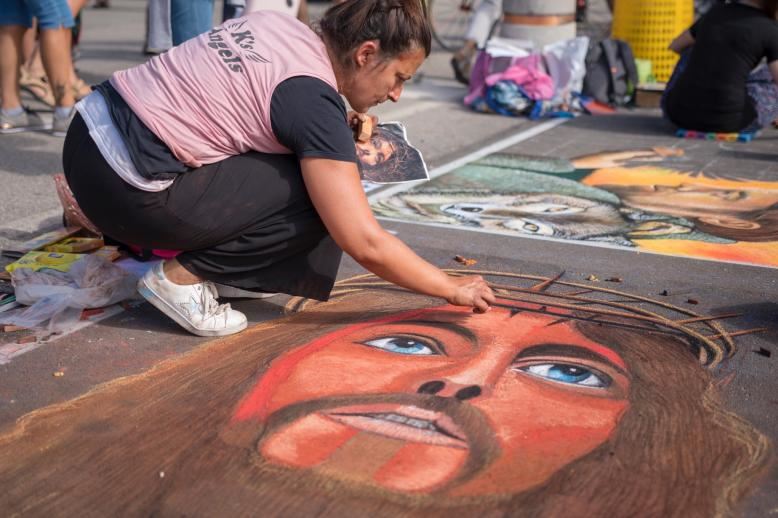 Un’artista madonnara al lavoro sul sagrato del Santuario delle Grazie di Curtatone (Mantova), in occasione dell’Incontro nazionale qui ospitato dal 1973 nell’ambito della Fiera delle Grazie che accompagna la festa dell’Assunta