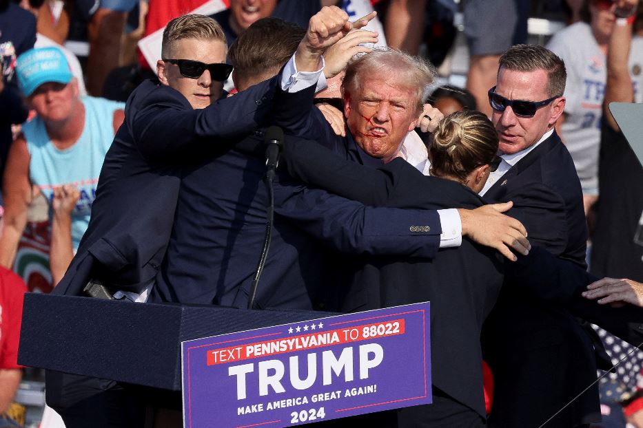 Donald Trump ferito sul palco, mentre gli uomini e le donne della security lo cingono