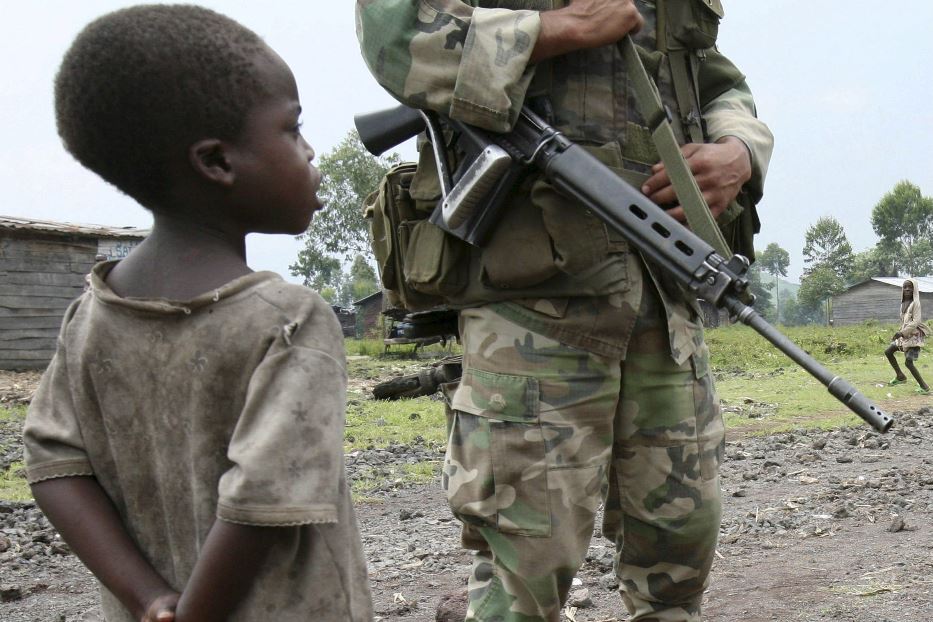 Un bimbo osserva i miliziani nell'Est del Congo