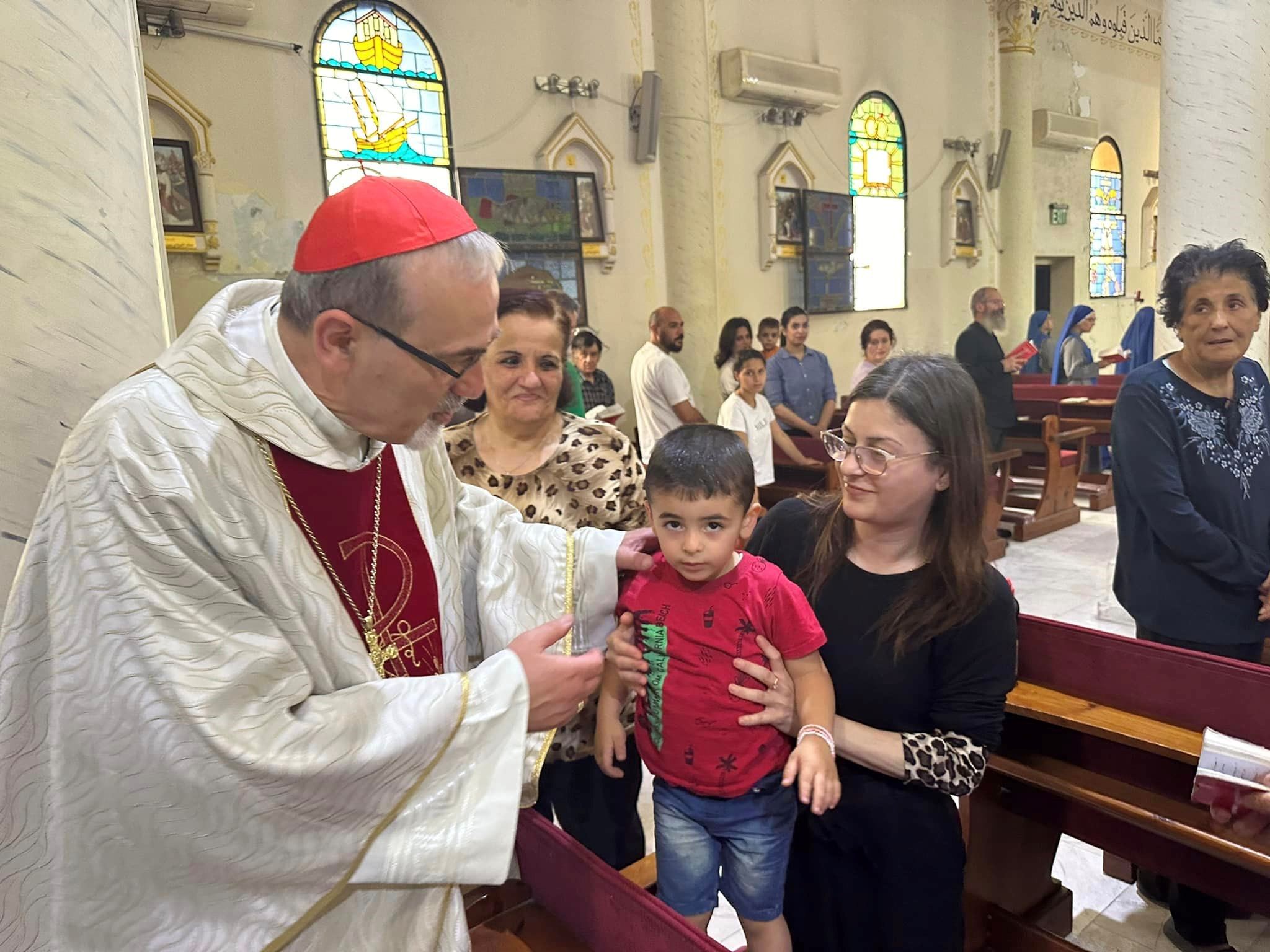 Il cardinale Pierbattista Pizzaballa saluta una famiglia nella parrocchia della Sacra famiglia a Gaza