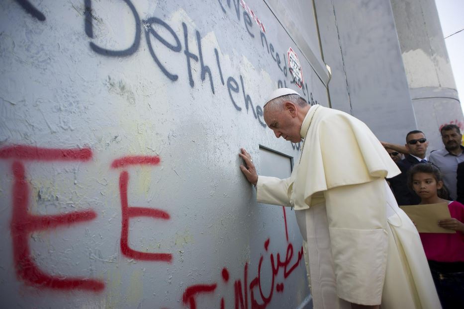 Papa Francesco in raccoglimento davanti al muro che separa Israele e Palestina nel maggio 2014