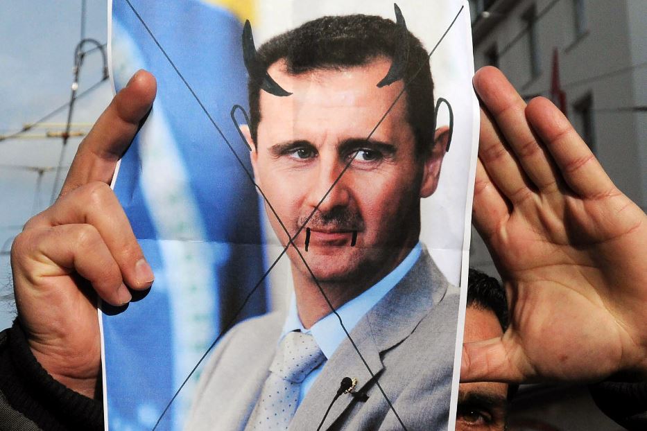 Una foto di Bashar al-Assad, "truccato" da diavolo, in mano ai ribelli