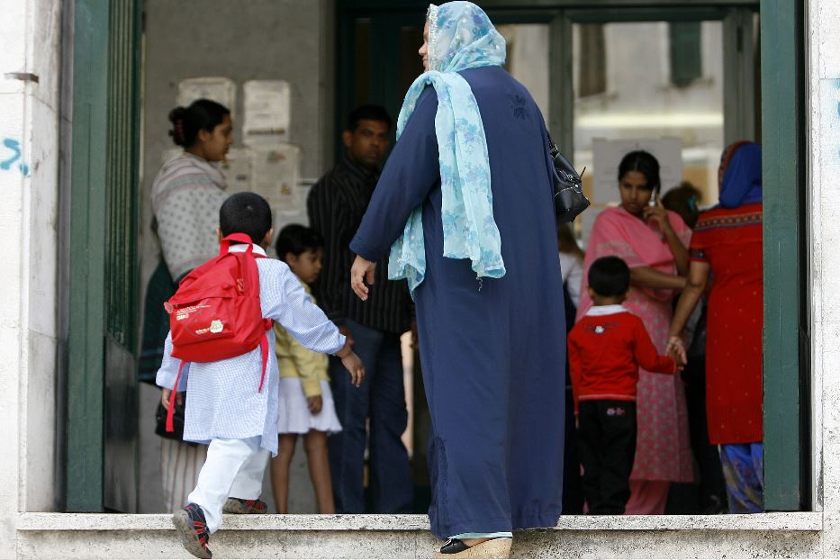 Madre e figlio stranieri all'ingresso di una scuola italiana