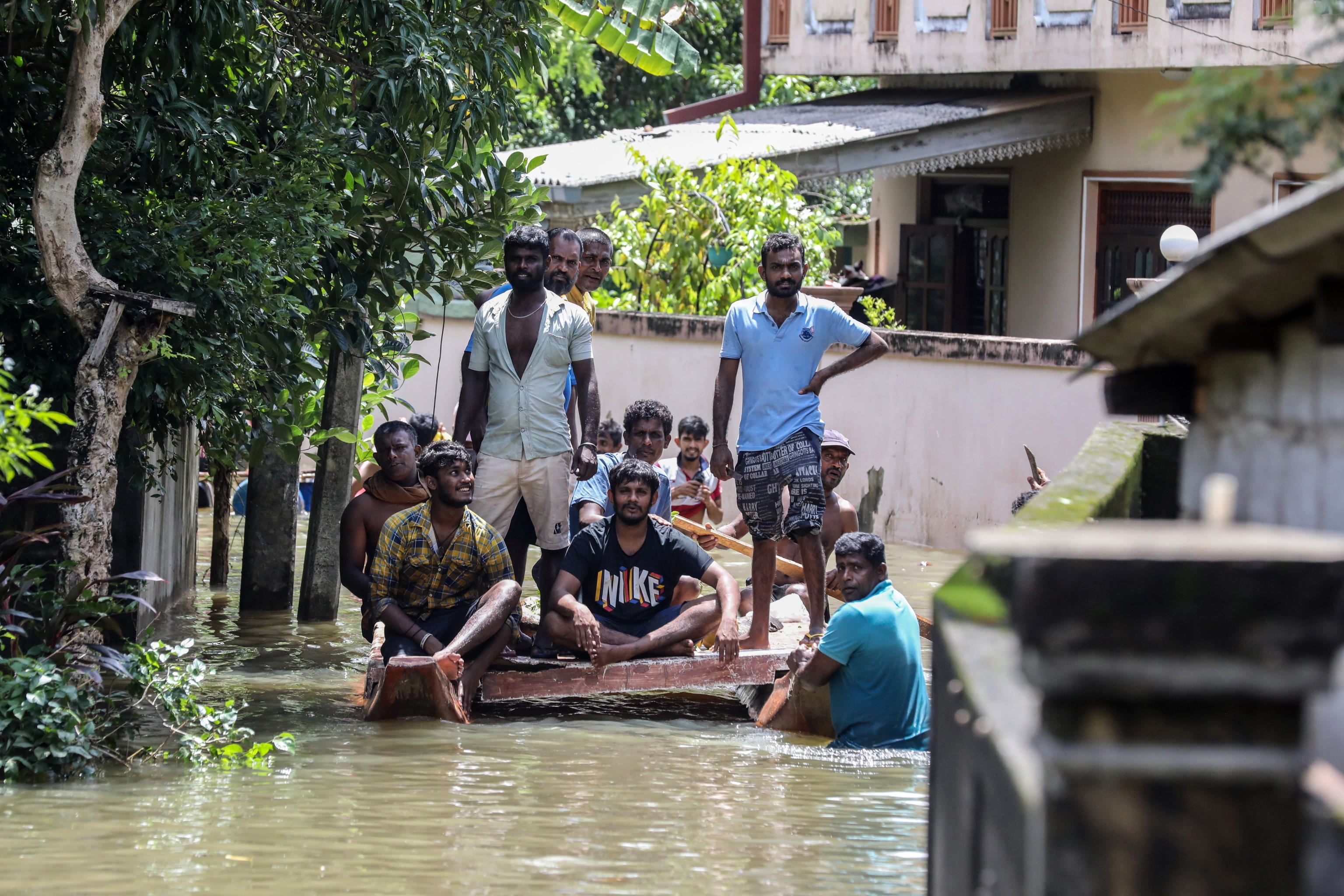 Alcune vittime dell'alluvione di inizio giugno attraversa su una zattera le strade della capitale Colombo