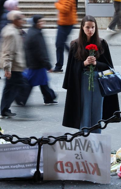Una ragazza depone una rosa per Navalny a Milano