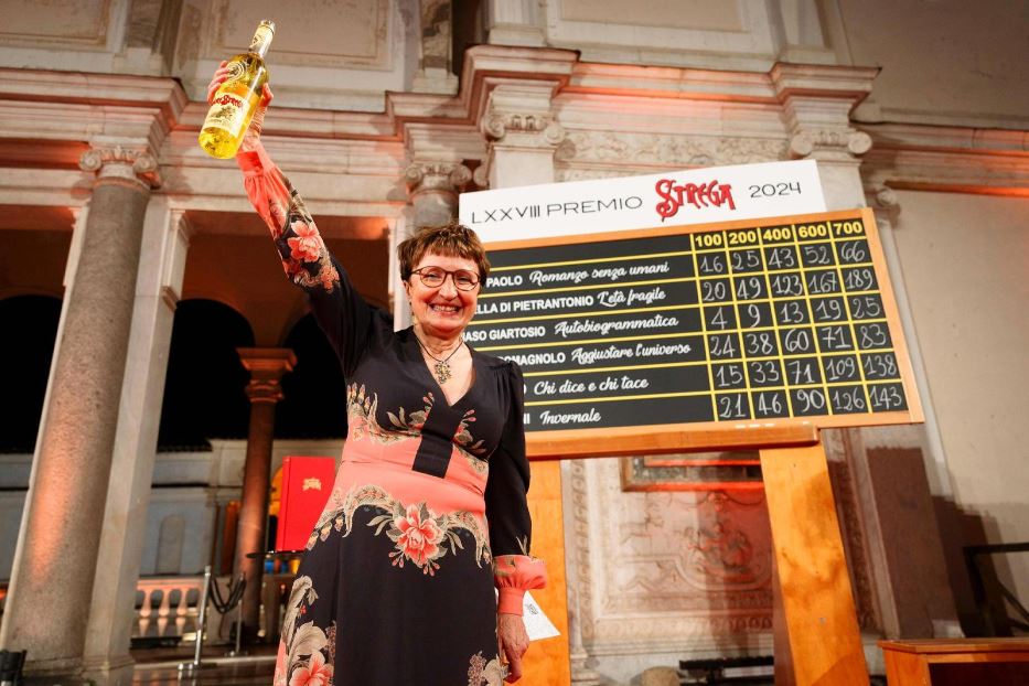 Donatella Di Pietrantonio alza una bottiglia di liquore per festeggiare la vittoria del Premio Strega, 4 luglio 2024